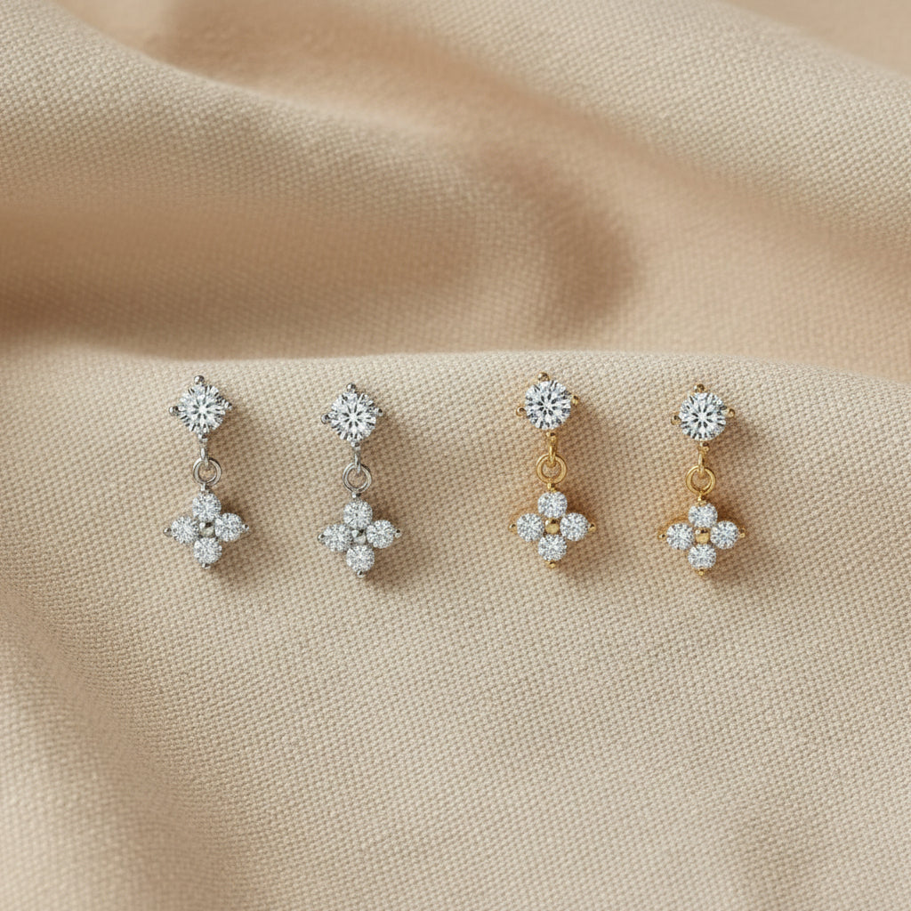 Two pairs of zircon crystal earrings in silver and gold.