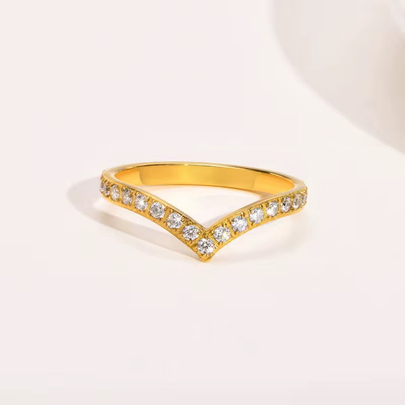 Gold ring with diamond accents on a light background