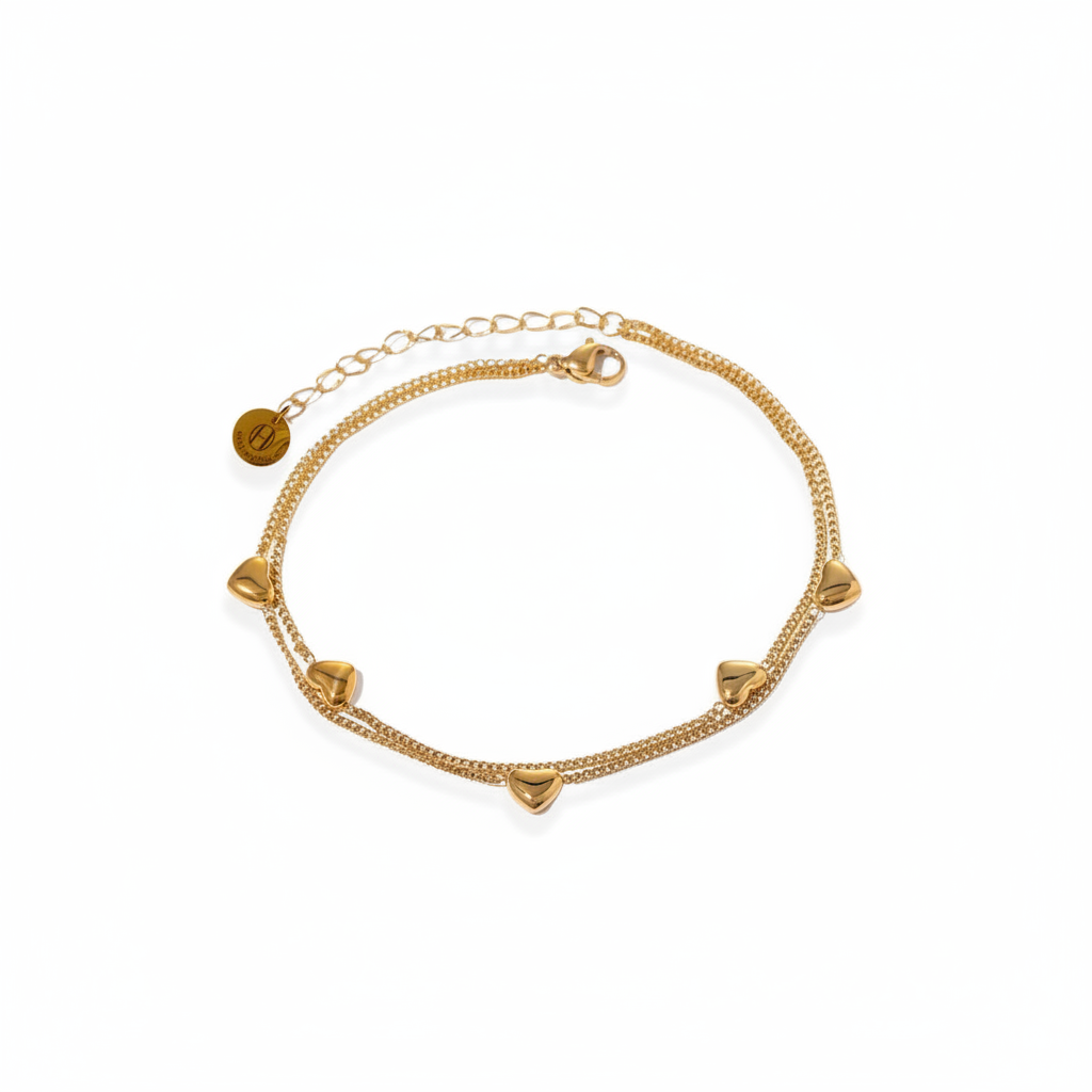 A gold-plated anklet with intricate heart designs, featuring a chain structure and a small heart-shaped detail.